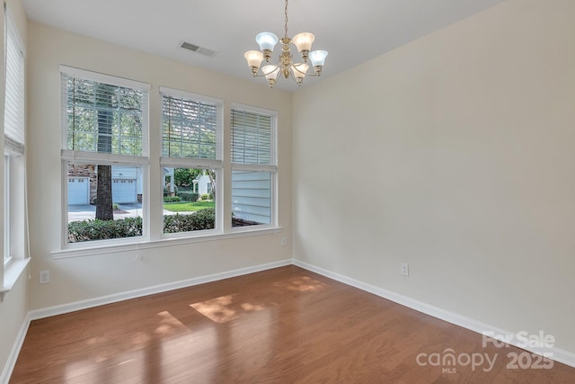 5963 Pale Moss Ln, Charlotte, NC 28269 - empty room featuring a chandelier, wood finished floors, and baseboards