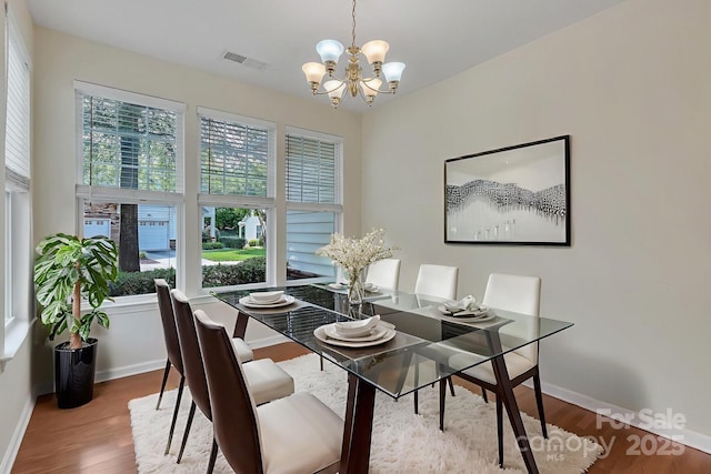 5963 Pale Moss Ln, Charlotte, NC 28269 - dining room featuring a chandelier, wood finished floors, and baseboards