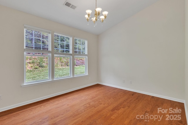 5963 Pale Moss Ln, Charlotte, NC 28269 - spare room featuring a chandelier, baseboards, healthy amount of natural light, and wood finished floors