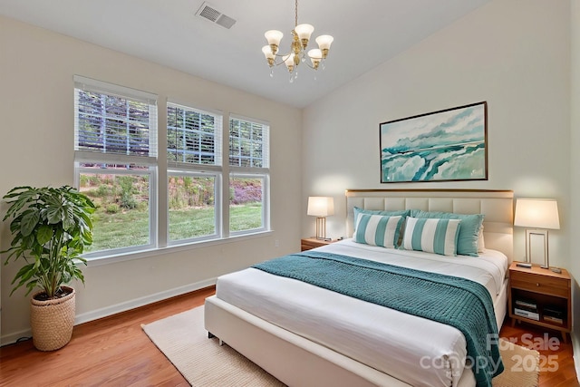 5963 Pale Moss Ln, Charlotte, NC 28269 - bedroom with a chandelier, wood finished floors, baseboards, and vaulted ceiling