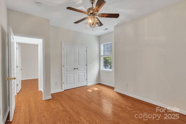 5963 Pale Moss Ln, Charlotte, NC 28269 - unfurnished bedroom with light wood-type flooring, baseboards, a closet, and ceiling fan