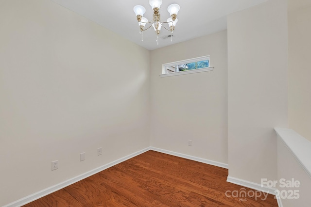 5963 Pale Moss Ln, Charlotte, NC 28269 - unfurnished room with a chandelier, wood finished floors, and baseboards