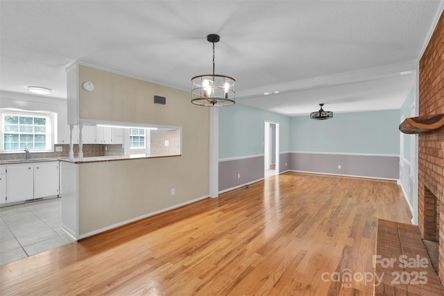 2326 Horseshoe Bend Rd NE, Hickory, NC 28601 - unfurnished living room featuring a chandelier and light wood-style floors