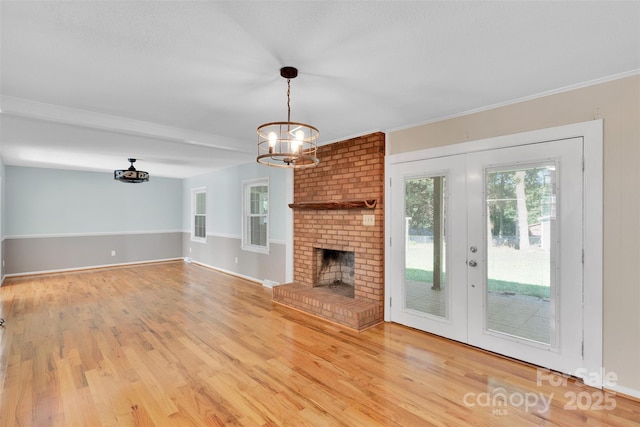 2326 Horseshoe Bend Rd NE, Hickory, NC 28601 - unfurnished living room featuring a chandelier, wood finished floors, french doors, a brick fireplace, and ornamental molding