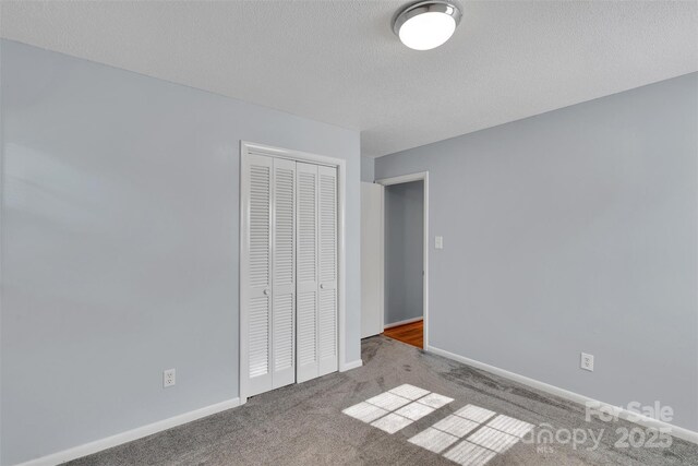 2326 Horseshoe Bend Rd NE, Hickory, NC 28601 - unfurnished bedroom featuring carpet, a closet, and a textured ceiling