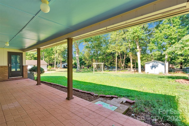 2326 Horseshoe Bend Rd NE, Hickory, NC 28601 - fenced backyard featuring a patio area, a storage unit, and view of wooded area