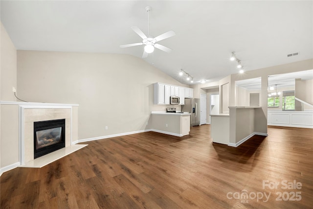 4510 Glenlea Commons Dr, Charlotte, NC 28216 - unfurnished living room with rail lighting, lofted ceiling, wood finished floors, a high end fireplace, and baseboards
