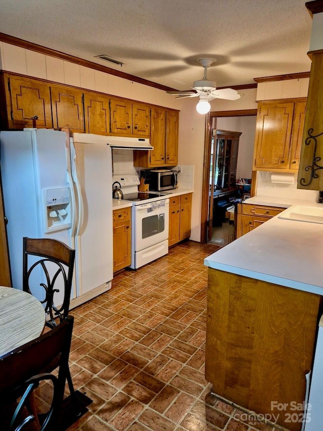 8616 Fallsdale Dr, Charlotte, NC 28214 - kitchen featuring white appliances, brown cabinetry, a ceiling fan, light countertops, and brick patterned flooring