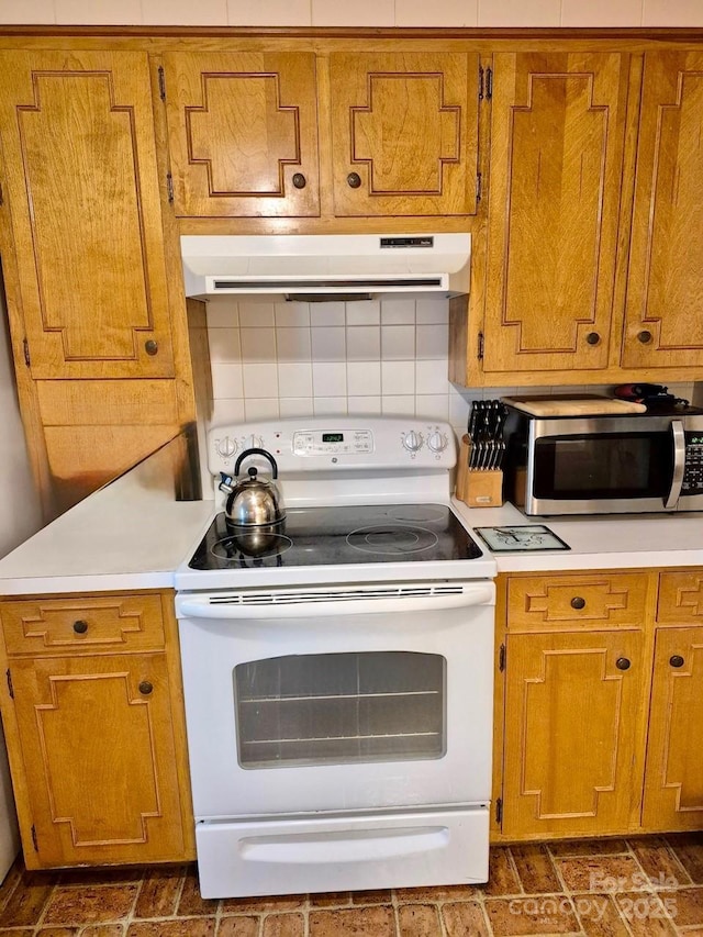 8616 Fallsdale Dr, Charlotte, NC 28214 - kitchen with white electric stove, stainless steel microwave, under cabinet range hood, and brown cabinetry