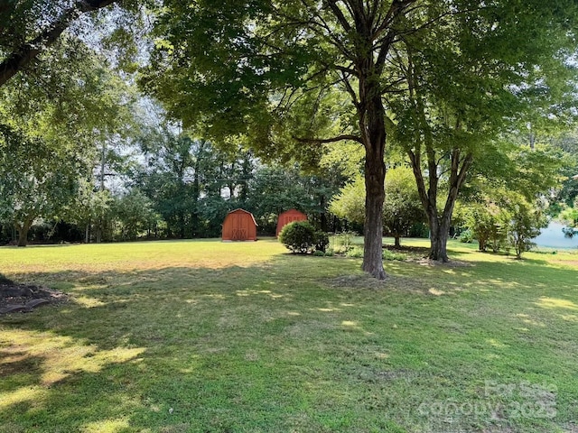 8616 Fallsdale Dr, Charlotte, NC 28214 - view of grassy yard featuring a barn, an outbuilding, and view of wooded area