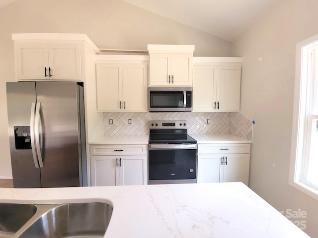 102 Lakeside Dr, Grover, NC 28073 - kitchen with appliances with stainless steel finishes, tasteful backsplash, lofted ceiling, white cabinets, and light stone countertops