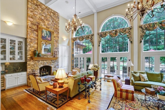 517 Kingsdown Ct, Waxhaw, NC 28173 - living room featuring a chandelier, a towering ceiling, light wood finished floors, healthy amount of natural light, and beamed ceiling