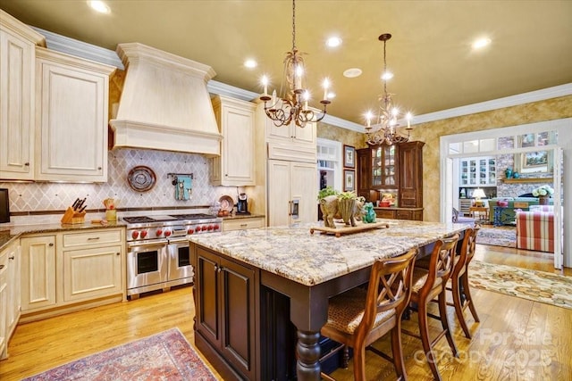 517 Kingsdown Ct, Waxhaw, NC 28173 - kitchen with premium appliances, custom range hood, light wood-type flooring, a chandelier, and ornamental molding