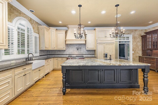 517 Kingsdown Ct, Waxhaw, NC 28173 - kitchen with a chandelier, paneled built in fridge, custom range hood, crown molding, and light wood-type flooring