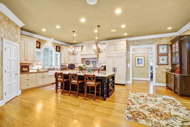 517 Kingsdown Ct, Waxhaw, NC 28173 - kitchen with a chandelier, paneled built in refrigerator, crown molding, a breakfast bar area, and custom range hood