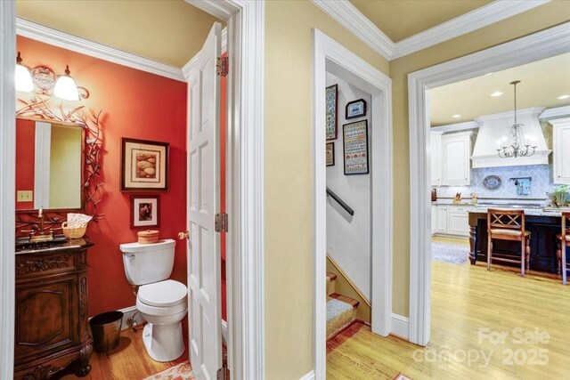 517 Kingsdown Ct, Waxhaw, NC 28173 - bathroom with wood finished floors, vanity, tasteful backsplash, crown molding, and a chandelier