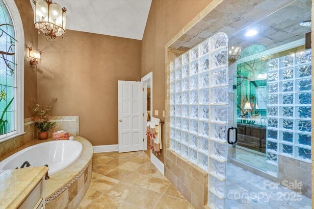 517 Kingsdown Ct, Waxhaw, NC 28173 - bathroom featuring a garden tub, a chandelier, and a shower stall