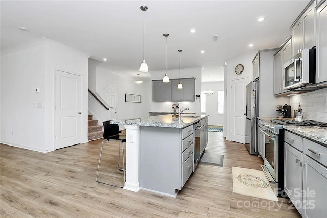 13140 Sudwick Ln, Charlotte, NC 28278 - kitchen featuring stainless steel appliances, gray cabinetry, a sink, a center island with sink, and recessed lighting