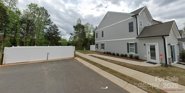 12016 Basking Dr, Charlotte, NC 28214 - view of property exterior with roof with shingles and a gate
