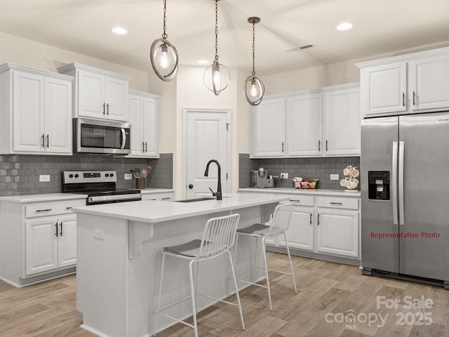 12016 Basking Dr, Charlotte, NC 28214 - kitchen with stainless steel appliances, a sink, light countertops, light wood-type flooring, and recessed lighting