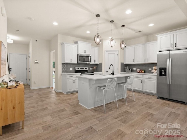 12016 Basking Dr, Charlotte, NC 28214 - kitchen featuring appliances with stainless steel finishes, light countertops, tasteful backsplash, light wood-style flooring, and recessed lighting