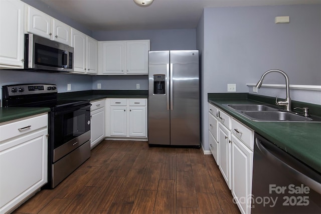 7623 Monarch Birch Ln, Charlotte, NC 28215 - kitchen with appliances with stainless steel finishes, a sink, dark wood-style flooring, white cabinetry, and dark countertops