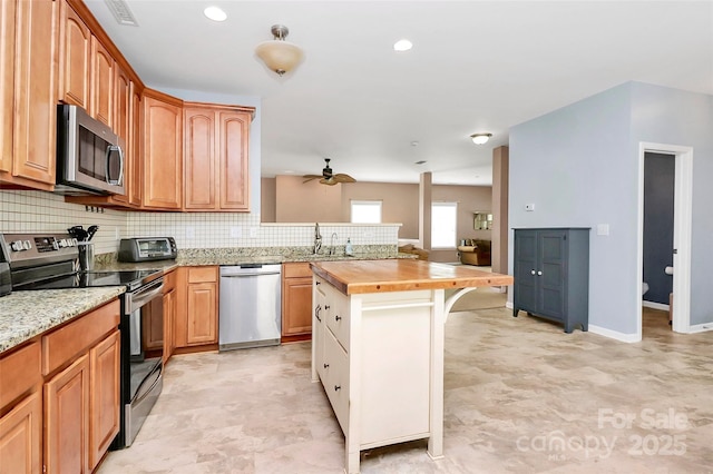 1817 Tradd Ave, Clover, SC 29710 - kitchen with stainless steel appliances, wooden counters, ceiling fan, tasteful backsplash, and a sink