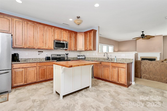 1817 Tradd Ave, Clover, SC 29710 - kitchen featuring appliances with stainless steel finishes, a sink, tasteful backsplash, butcher block countertops, and a ceiling fan