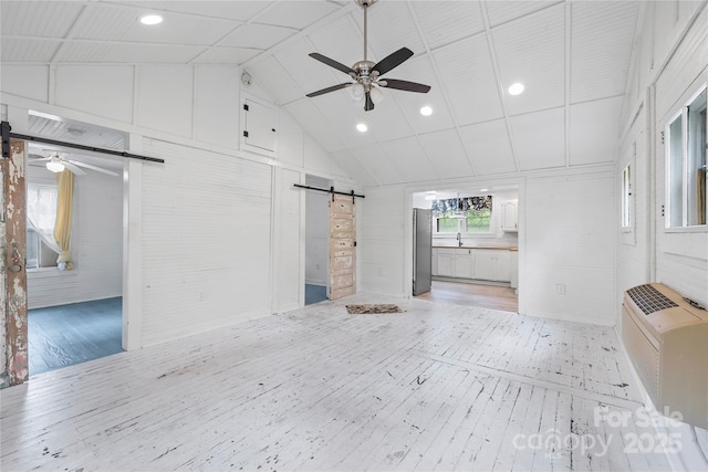 220 W College St, Black Mountain, NC 28711 - unfurnished living room featuring a barn door, light wood-style flooring, ceiling fan, lofted ceiling, and recessed lighting