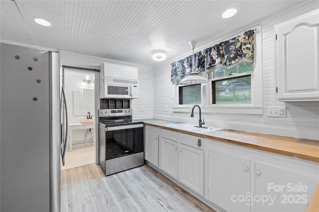 220 W College St, Black Mountain, NC 28711 - kitchen featuring electric stove, freestanding refrigerator, white microwave, butcher block counters, and white cabinets
