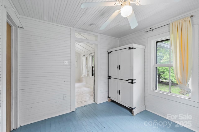220 W College St, Black Mountain, NC 28711 - unfurnished bedroom featuring light wood-style flooring, ceiling fan, and wooden walls