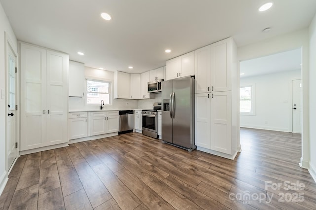 3608 Crestridge Dr, Charlotte, NC 28217 - kitchen featuring appliances with stainless steel finishes, dark wood-style flooring, white cabinets, light countertops, and recessed lighting
