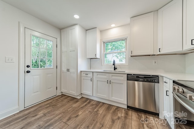 3608 Crestridge Dr, Charlotte, NC 28217 - kitchen with stainless steel dishwasher, a sink, wood finished floors, range, and light countertops
