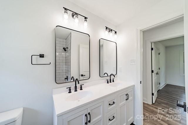 3608 Crestridge Dr, Charlotte, NC 28217 - bathroom featuring double vanity, toilet, wood finished floors, and tiled shower