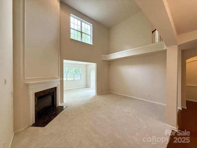 1304 Ridge Haven Rd, Waxhaw, NC 28173 - unfurnished living room with healthy amount of natural light, carpet floors, a premium fireplace, a high ceiling, and baseboards