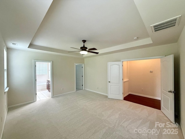 1304 Ridge Haven Rd, Waxhaw, NC 28173 - unfurnished bedroom with a tray ceiling, carpet flooring, ceiling fan, and ensuite bath