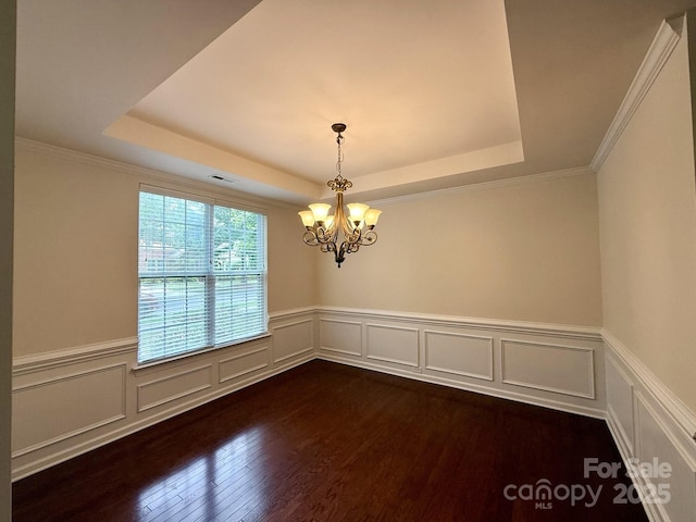 1304 Ridge Haven Rd, Waxhaw, NC 28173 - spare room featuring a tray ceiling, a chandelier, dark wood-type flooring, wainscoting, and a decorative wall