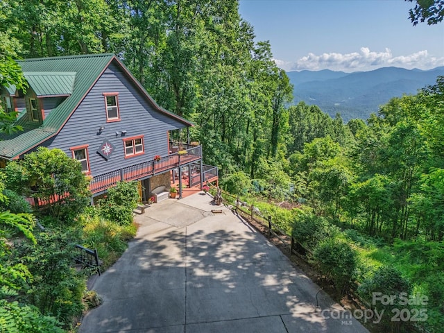 2981 Heath Peak Rd, Waynesville, NC 28785 - view of property exterior featuring concrete driveway, a mountain view, and a view of trees