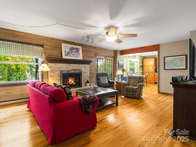 2981 Heath Peak Rd, Waynesville, NC 28785 - living area featuring a ceiling fan, a stone fireplace, light wood-style floors, and baseboard heating