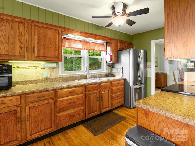 2981 Heath Peak Rd, Waynesville, NC 28785 - kitchen with freestanding refrigerator, light wood-style flooring, brown cabinets, and light countertops