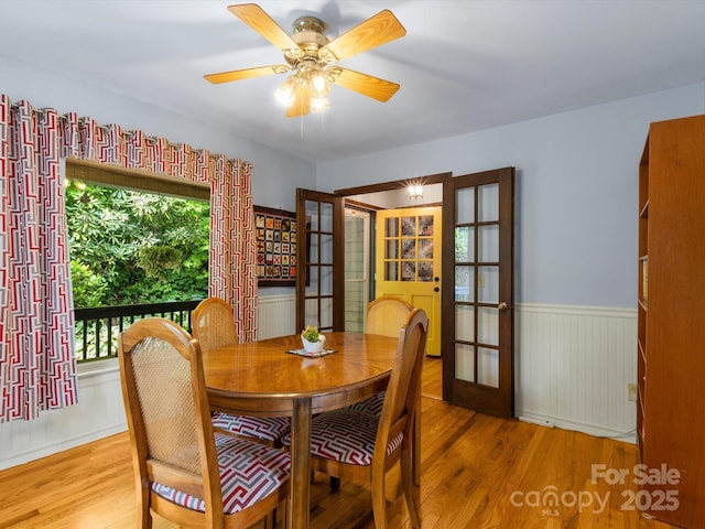 2981 Heath Peak Rd, Waynesville, NC 28785 - dining area with french doors, wood finished floors, wainscoting, and a ceiling fan