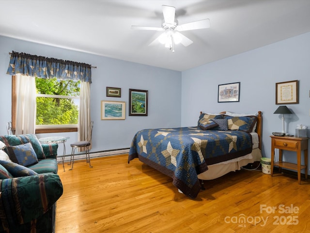 2981 Heath Peak Rd, Waynesville, NC 28785 - bedroom featuring baseboard heating, light wood-style flooring, and ceiling fan