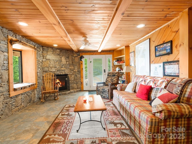 2981 Heath Peak Rd, Waynesville, NC 28785 - living area featuring a wood ceiling with exposed beams, stone finish flooring, ceiling fan, and a stone fireplace