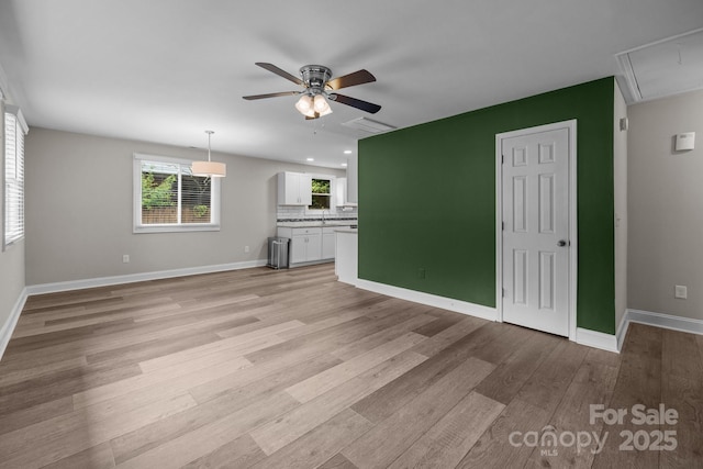 5008 Unaka Ave, Charlotte, NC 28205 - unfurnished living room with ceiling fan, light wood-style floors, attic access, recessed lighting, and arched walkways