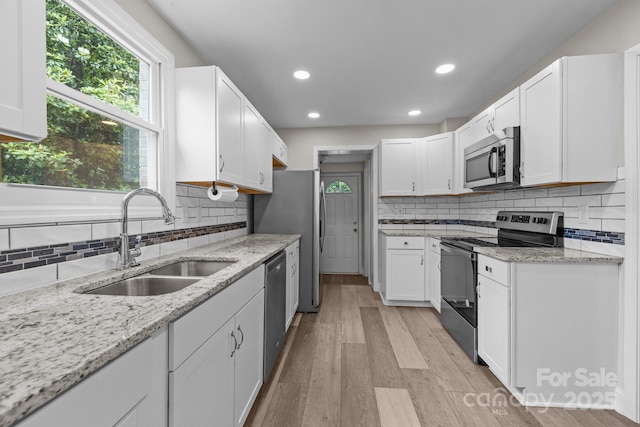 5008 Unaka Ave, Charlotte, NC 28205 - kitchen featuring stainless steel appliances, white cabinets, decorative backsplash, light stone counters, and recessed lighting