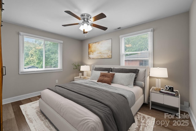 5008 Unaka Ave, Charlotte, NC 28205 - bedroom with multiple windows, wood finished floors, and a ceiling fan