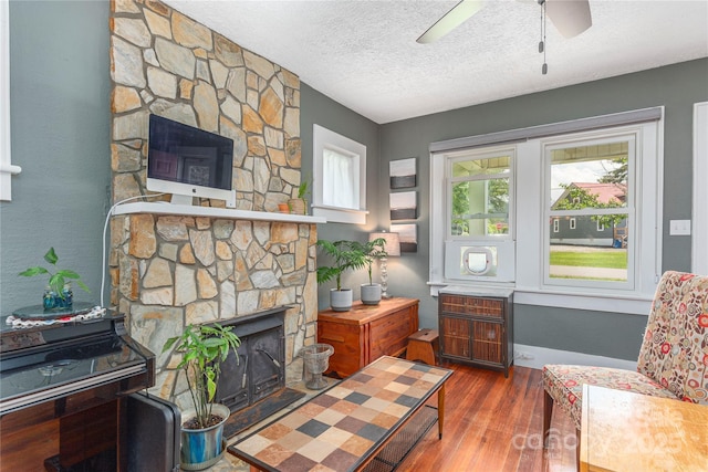 10 Poplar St, Waynesville, NC 28786 - living room featuring wood finished floors, a fireplace, ceiling fan, and a textured ceiling