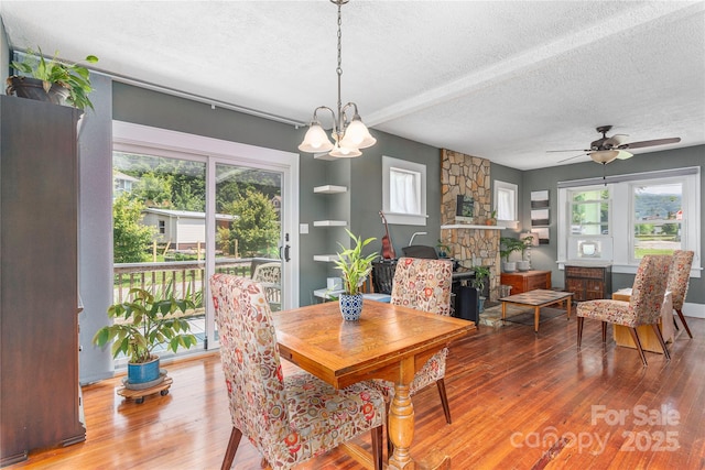 10 Poplar St, Waynesville, NC 28786 - dining area featuring a textured ceiling, healthy amount of natural light, wood finished floors, a chandelier, and a ceiling fan