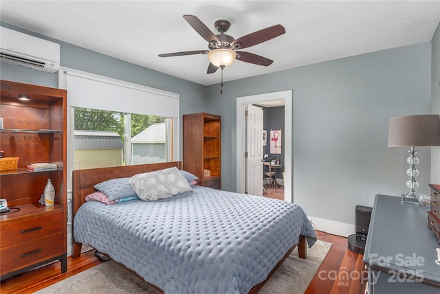 10 Poplar St, Waynesville, NC 28786 - bedroom with an AC wall unit, wood finished floors, ceiling fan, and baseboards