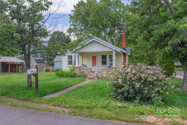 10 Poplar St, Waynesville, NC 28786 - bungalow-style house featuring a chimney, a front lawn, and a porch